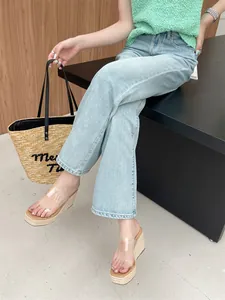 Fashionable women's wedge slippers with clear straps and straw platform on model