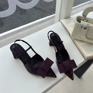 Elegant deep burgundy patent leather pointed-toe slingback heels with stylish fabric bows