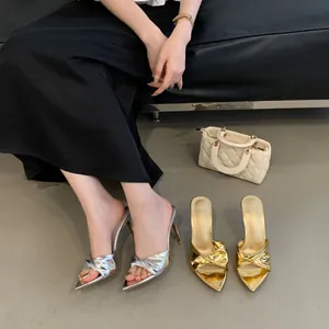 Detailansicht sexy spitzer High-Heel-Sandalen mit metallischem Knotendesign in Gold und Silber