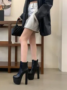Stylish black 16cm high heel platform Chelsea boots with thick heels worn by a model
