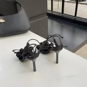 Elegante schwarze Stilettosandalen mit Schnürung, feinen Knöchelbändern und schmalem Absatz.