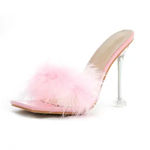 Close-up view of pink feather mule slippers with transparent high heels and square toe