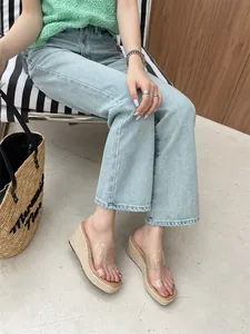 Stylish women's transparent strap wedge sandals with straw platform shown on model