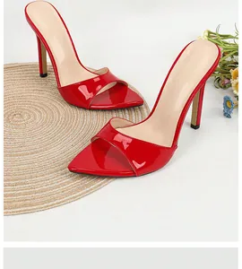 Close-up of elegant red patent leather stiletto sandals with pointed open toe design