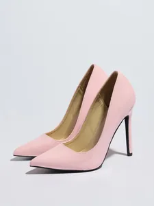 Vista detallada de elegantes stilettos rosa de charol con punta afilada clásica