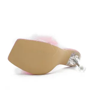 Detailed view of the transparent high heel and textured sole of pink feather sandals