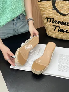 Detailed view of summer wedge sandals with clear straps and platform braided sole.