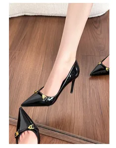 Close-up of elegant black patent leather pointed-toe stilettos with gold buckle detail