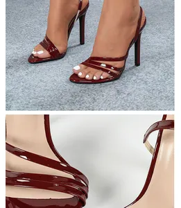 Detailed macro view showing the glossy burgundy patent leather straps of stiletto sandals.
