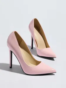 Vista lateral de elegantes tacones de aguja en charol rosa con punta afilada para mujer