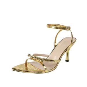 Elegant gold pointed toe high heel sandals featuring bow detail and stone texture