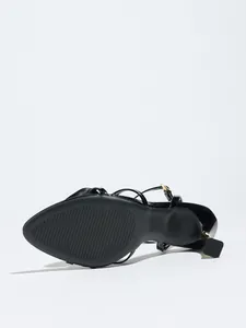 Detailed bottom view of a black stiletto sandal showing the textured sole and size mark