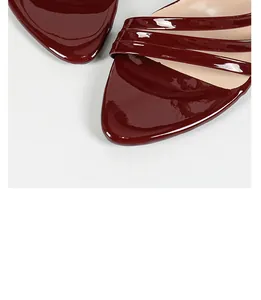 Close-up detail of elegant burgundy patent leather pointed toe strap high heel sandals