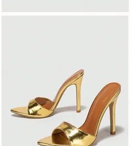 Detailed view of elegant gold metallic stiletto high heel sandals with pointed toes.