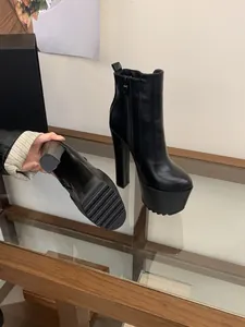 Detailed view of the 16cm platform block heel and anti-slip sole on black boots