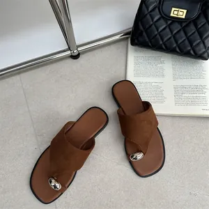 Stijlvolle bruine platte teenslippers met ovale zilveren gesp in lifestyle setting