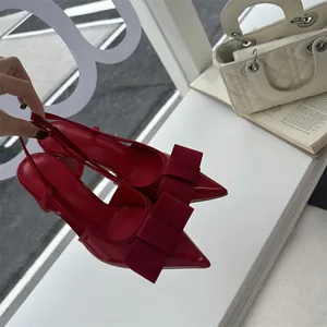 Detailed view of red patent leather slingback pumps with elegant bow and pointed toe