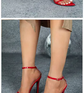Detailed macro view of red patent leather high heel sandals with an ankle strap and stiletto.