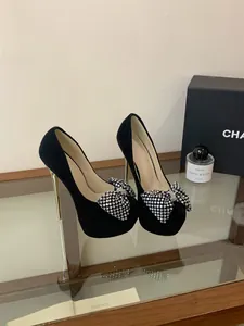 Elegant black platform high heels featuring a rhinestone bow and gold stiletto heel