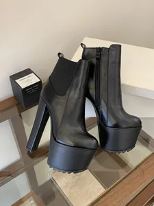 Close-up detail of 16cm black platform ankle boots featuring chunky high heels and side zip