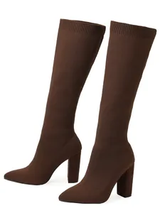 Detailed view of elegant brown knitted stretch knee-high boots with chunky high heels.