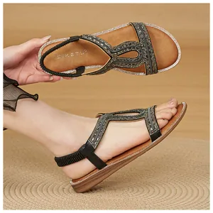 Vista dettagliata di sandali bassi bohémien con strass scintillanti e fascia elastica.