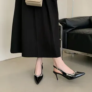Elegante schwarze Lackleder-Pumps mit Kristallbesatz von Modell getragen