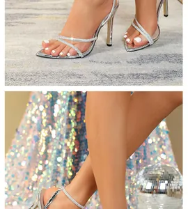 Dettaglio di eleganti sandali a spillo argento con strass e cinturini incrociati