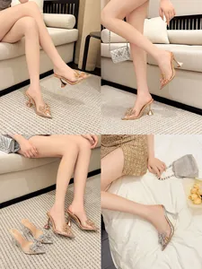 Detailaufnahmen von klaren PVC-High-Heels mit funkelnder Strass-Schleife am Zehenbereich.