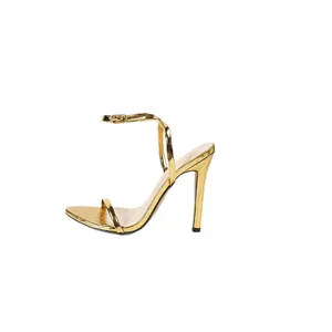 Eleganti sandali metallizzati oro con tacco a spillo e cinturino alla caviglia.