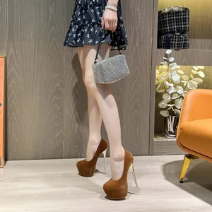 Close-up of brown platform stiletto pumps with gold heels on a model