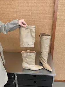 Detail view showing the two-way wearable design of beige pointed-toe knight boots.