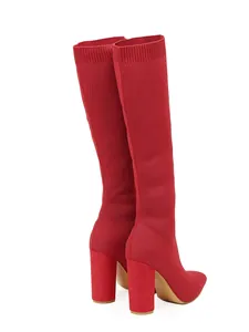 Detailed view of red knitted tall boots with pointed toe and chunky block heel.
