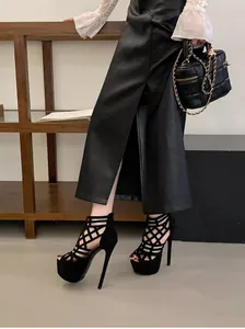 Fashionable detail of 16cm platform cage high heels worn with a black leather skirt