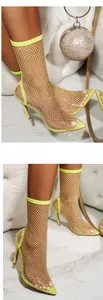 Detail of neon yellow mesh ankle boots with shimmering rhinestone embellishments.