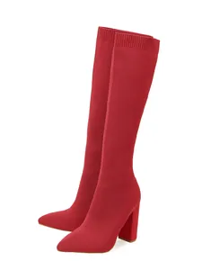 Side view of vibrant red knit stretch knee high boots featuring pointed toe and chunky heel.