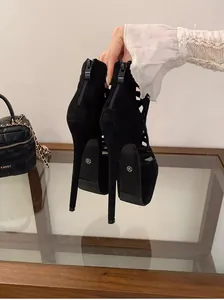 Close-up of black 16cm platform stiletto heels with cutout design and back zipper.