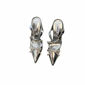 Top view of silver high-heeled sandals featuring sparkling rhinestone bow details