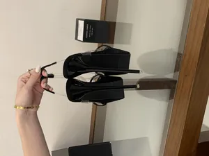 Detailed close-up of 16cm stiletto heels and platform on black catwalk sandals