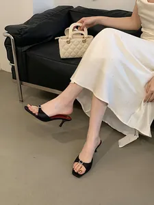 Elegant black stiletto sandals featuring a chic rhinestone buckle and square toe