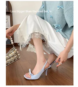 Detail of French style light blue bow open-toe sandals with stiletto high heels