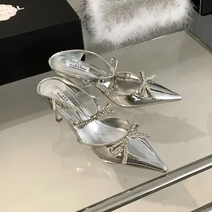 Elegant silver pointed-toe kitten heel sandals featuring sparkly rhinestone bow details.