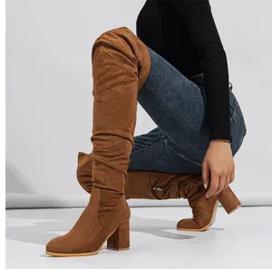 Side view of stylish brown suede over-the-knee boots with a comfortable block heel