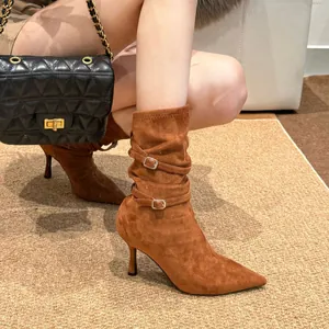 Detail showing texture of brown suede pointed toe stiletto boots with slouchy buckles