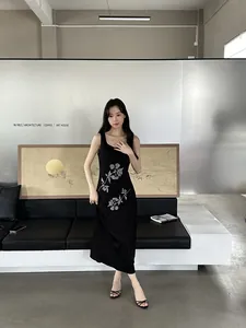 Sandales élégantes à petits talons noirs avec fines brides portées par un mannequin.