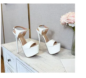 Elegant white platform stiletto sandals with ankle straps on a vintage white cabinet