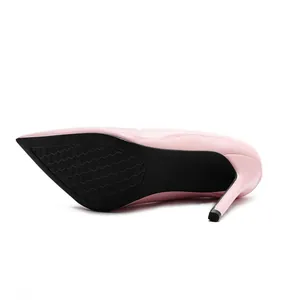 Macro detail view of elegant pink patent leather stiletto pump with black textured rubber sole