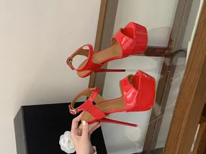 Détail de sandales sexy en cuir verni rouge à plateforme avec talons aiguilles ultra hauts