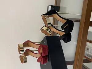 Detailed side view of sexy platform stiletto sandals featuring metallic gold ankle straps.