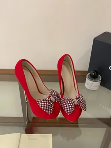 Elegant red velvet platform stiletto high heels featuring a large sparkling rhinestone bow